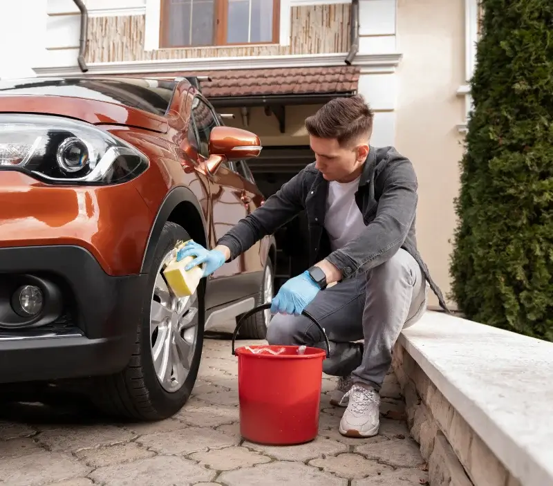 Lavage auto à domicile Oudincourt : professionnel intervenant sur un véhicule